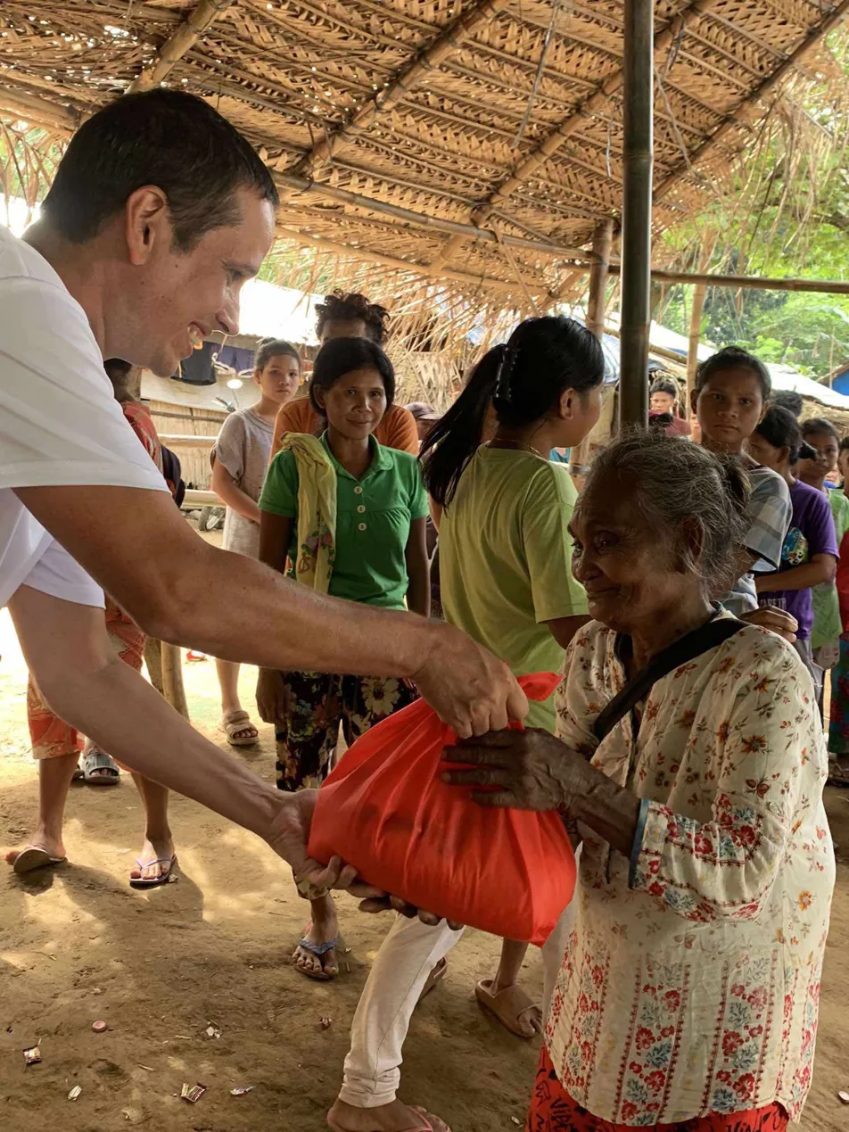 Jesse Gillispie handing supplies to a Mangyan elder in Mindoro, Philippines