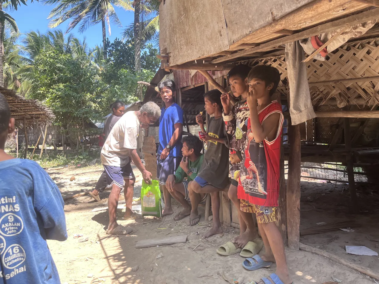 Mangyan boys standing in front of a bamboo house